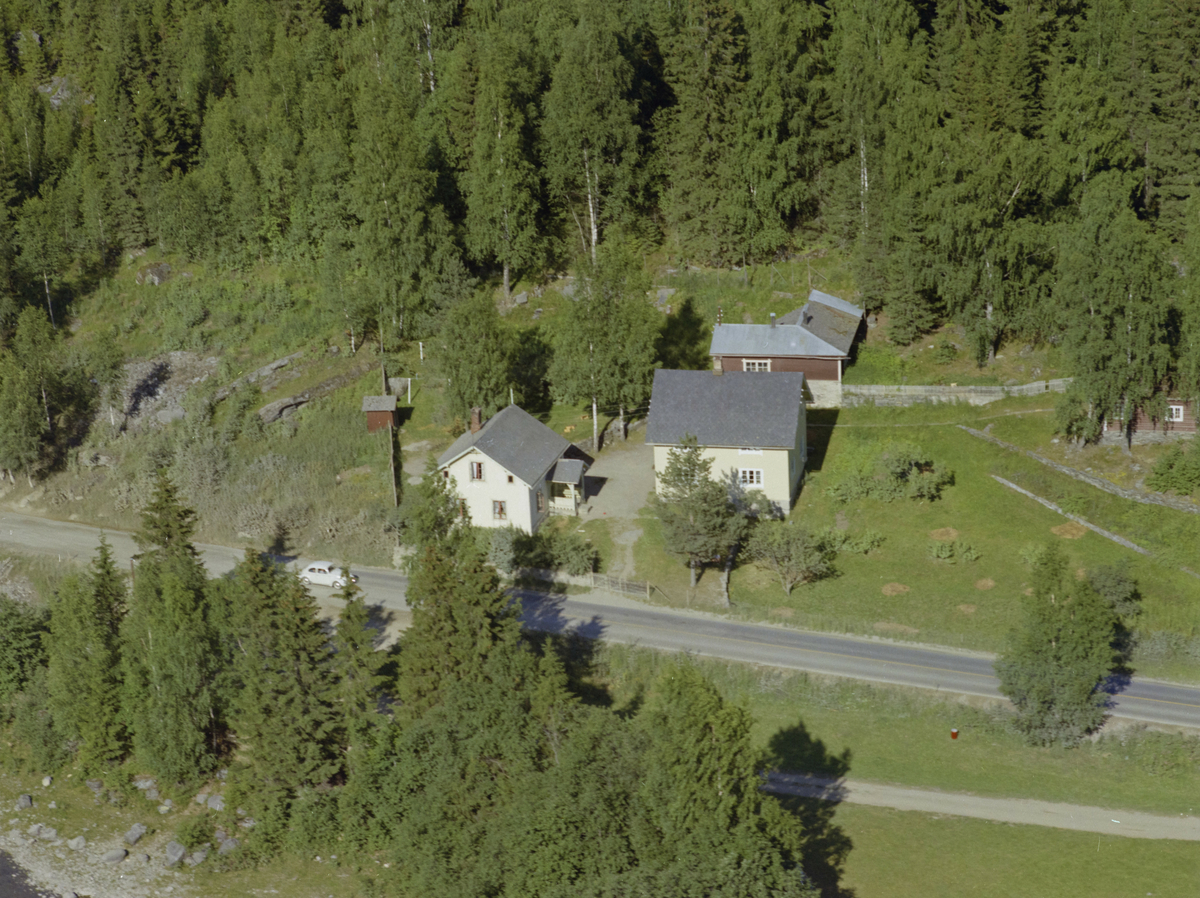 Øyer, Nord-Tretten. Bergseth. To våningshus, nitti grader på hverandre. Enetasjes, hvitmalte, et brunmalt vinkelhus i bakgrunnen, ewt lite rødt hus til venstre og et brunt hus til høyre, skjult i av bjørker. Ligger inntil gmale E6, hvor vi ser en VW boble på veg sørover.