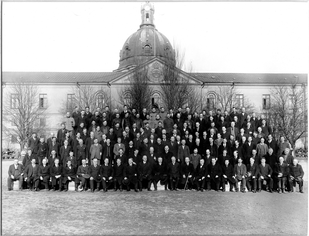 Grupporträtt av parsonalen vid Stockholms tygstation framför Poltavamonumentet mitt på Artillerigården 1927. Dagens Armémuseum.