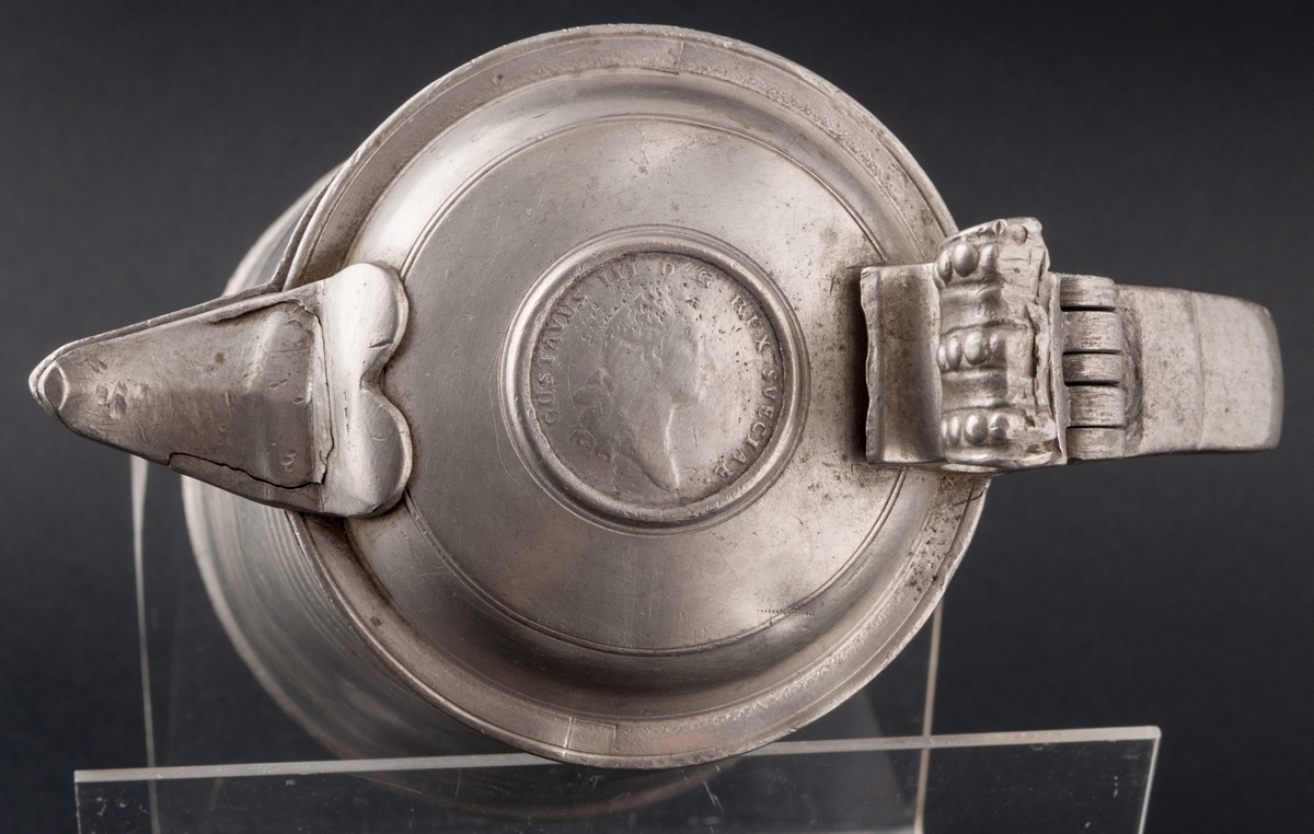 Tennstop med Gustav III-medalj i locket.