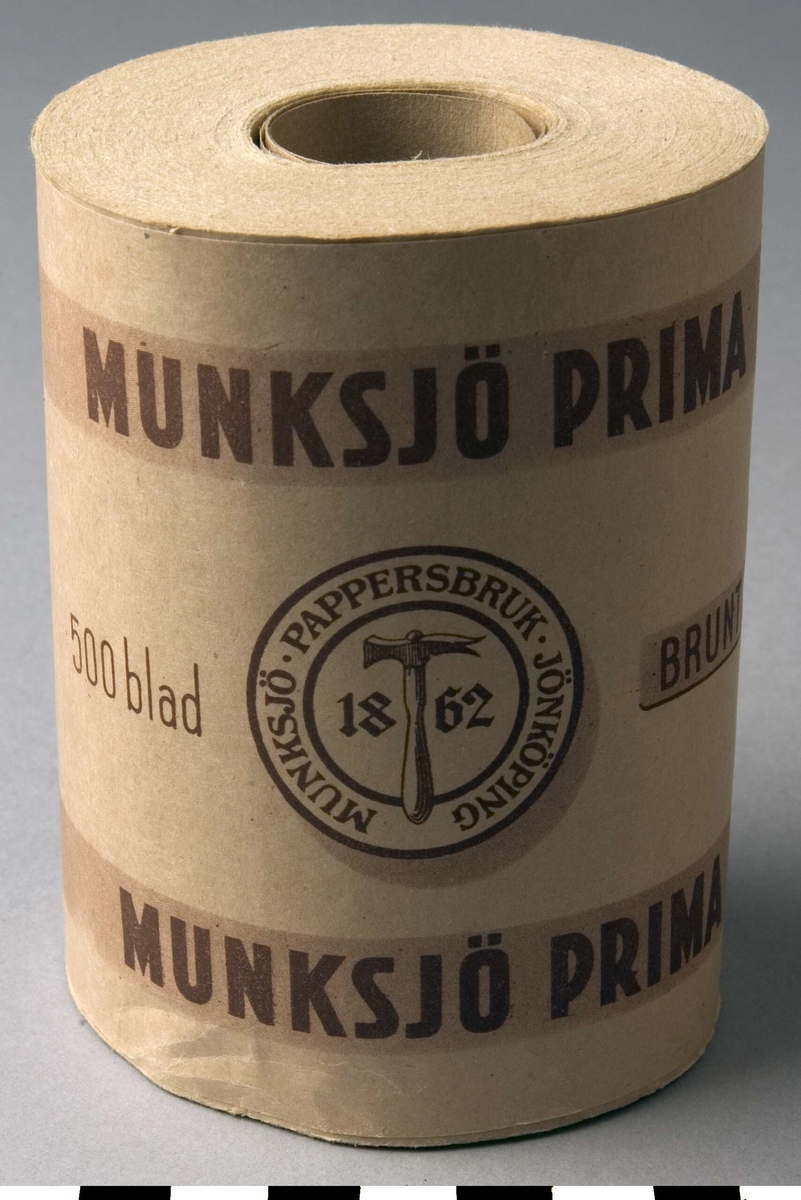Förpackning, toalettpappersrulle, 8 st, A-H.
Pappersrulle i mitten, med pårullat toalettpapper. Ytterst ett pappersomslag med  dekor och text i brunt. Dekor: Två koncentriska ringar med texten: MUNKSJÖ PAPPERSBRUK. JÖNKÖPING emellan och en hammare och 1862 i mitten. Ovanför och under ljusbrunt band med texten: MUNKSJÖ PRIMA två gånger på varje. Övrig text: 500 blad, Brunt.
Längst ned står: J.509 JJÖNKÖPINGS LITOGRAFISKA AKTIEBOLAG.