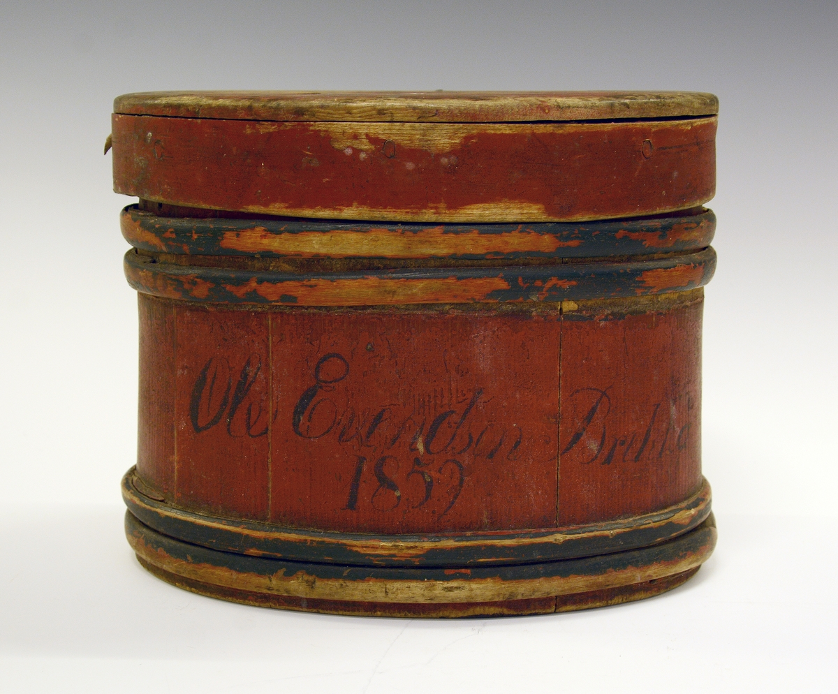 Eske (ask) med lokk. Lagget. Brunmalt med blå gjorder. Påskrevet "Ole Evendsen Brekka 1859". I bunnen er innskåret "1823" og "O".