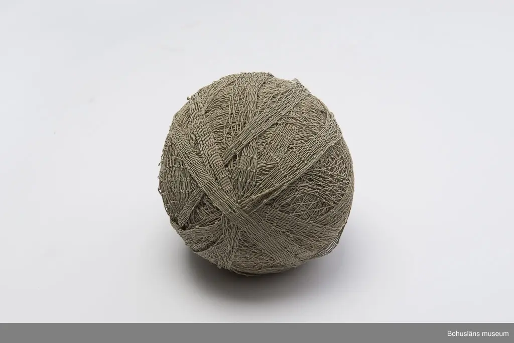 Runt, grå-beige garnnystan bestående av kasserat fisknät.