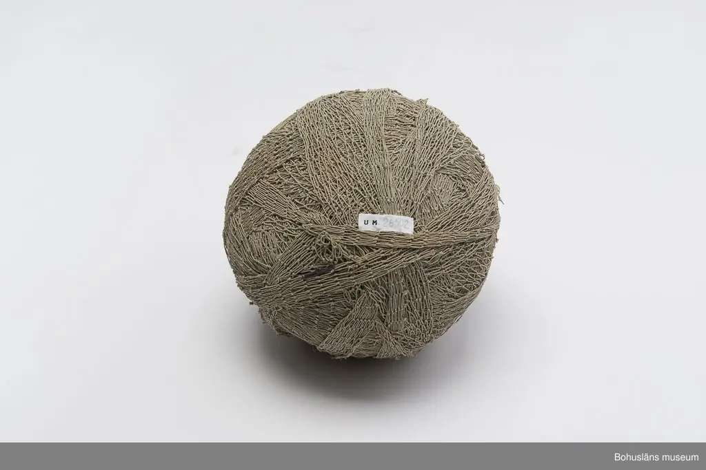 Runt, grå-beige garnnystan bestående av kasserat fisknät.