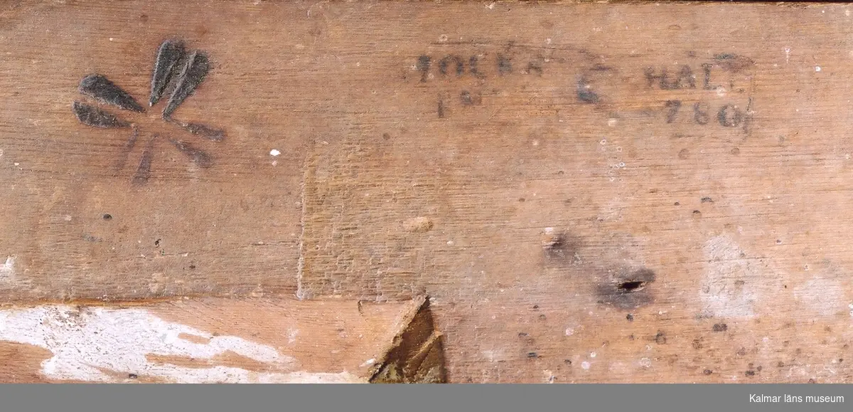 KLM 31938. Spegel. Förgylld bred ram av trä med pärlstav närmast spegeln och ytterkanten med äggstavsmönster. Krönet försett med en ros på vardera sida om en lagerkrans bunden med en rosett. Allt i relief. Svårläsbar stämpel på ramens baksida tockh..hal, 780, kan tolkas som: Stockholm Hallrättsstämpel, 1780. Nyare spegelglas.