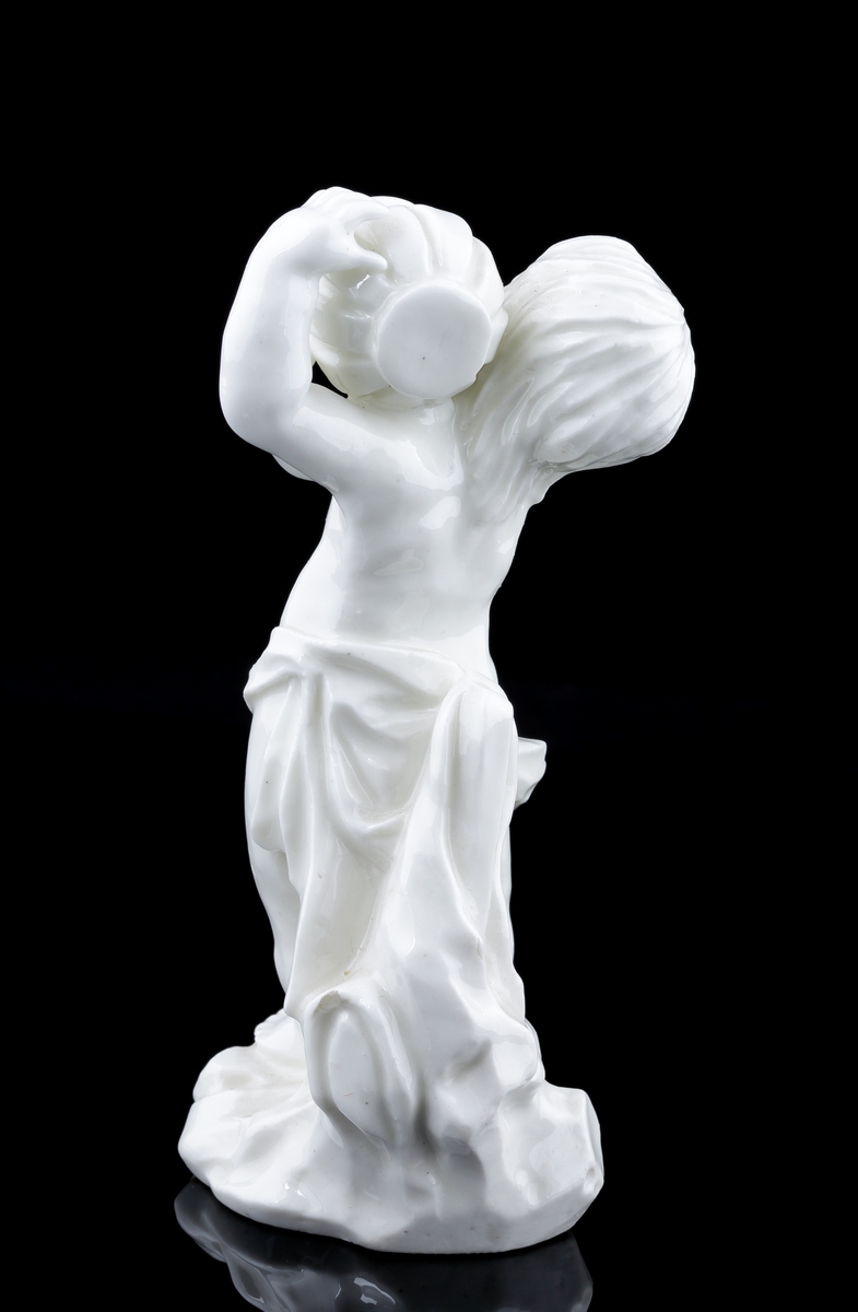 Figurin i vitt porslin, föreställande ett barn eller en putti hållandes i en urna, ur vilken innehållet rinner ut.
Personen är naken, men över livet täckt med ett kläde.