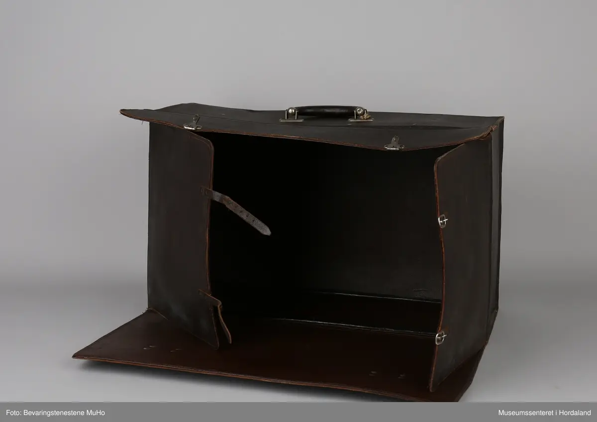 Rektangulær koffert i brunt skinn med eitt rom. Brukt av seljar ved Irisfabrikken i Os. Brukt til å oppbevare og transportere prøvar på kolleksjonen til potensielle kundar.