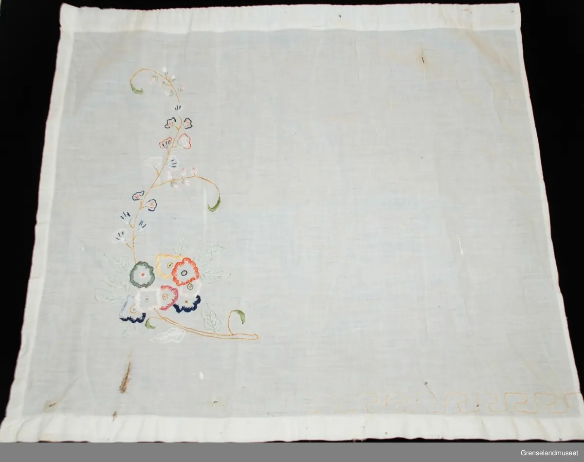 gardinene består av to små fag for nederdelen av stuevindu. Brodert med blomstermotiv i tungesting, kontursting og sjattersøm. Rundt gardinen er en z-kant sydd med sparesting. Løpegang for gardinwire.