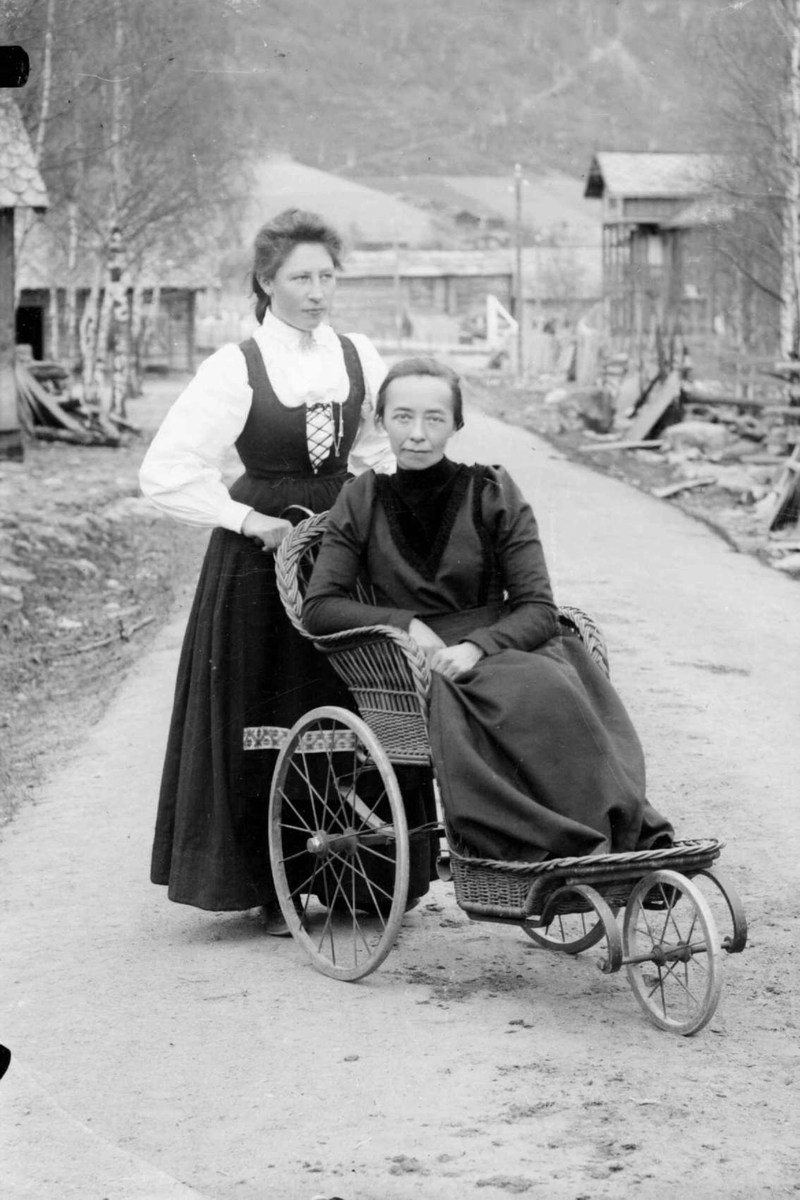 2 kvinner, en sitter i rullestol  av rotting