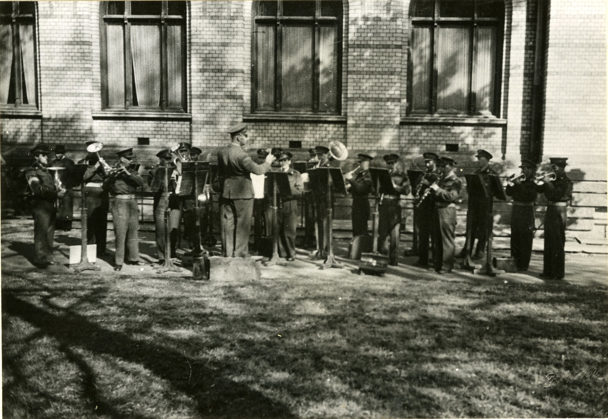 Musikkorps som spiller konsert foran Frimurerlogen i Trondheim. Alf Mostad som dirigent.