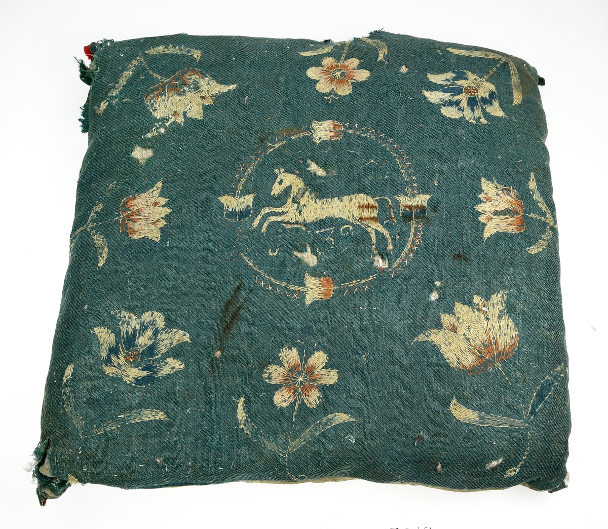 Pute av ull brodert med blomster- og dyremotiv og med underside av skinn