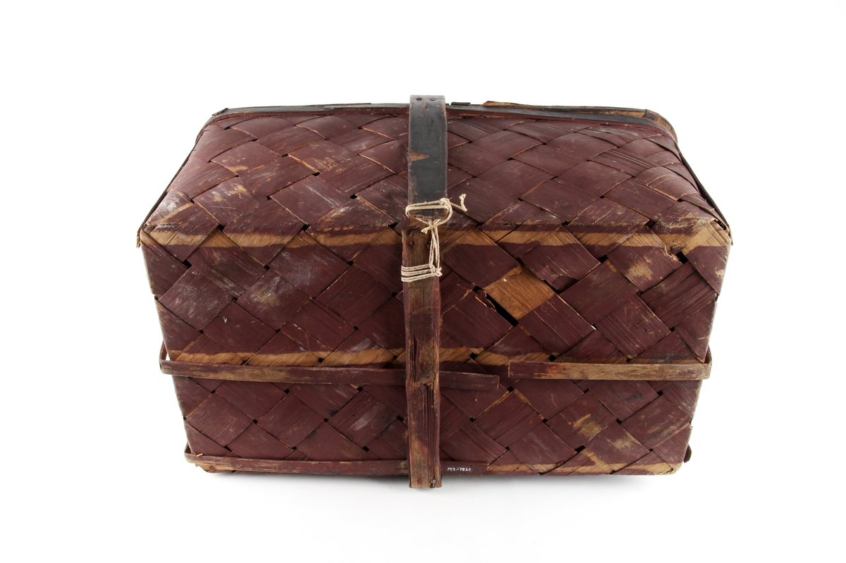 Brunmalt korg flettet av spon. En stor rund hank på midten og to lokk. Bare det ene kan åpnes.