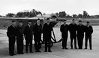 F6, Karlsborg 1969 - 30-årsjubileum. Flygdagarna. Personal som ansvarade för den äldre delen i flottiljens markutställning. Från vänster: Lennart Ramström, en värnpliktig, Bengt Larsson, Arne Wennlert, Folke Eriksson, Rune Larsson, Nils-Arne Selin, Rickard Lilja, Karl-Axel Hansson. I bakgrunden: ett Nieuport-monoplan. Albumet är en del av en donation från Karl-Axel Hansson, Karlsborg. Förteckning över hela donationen finns i albumet samt som Word-dokument.