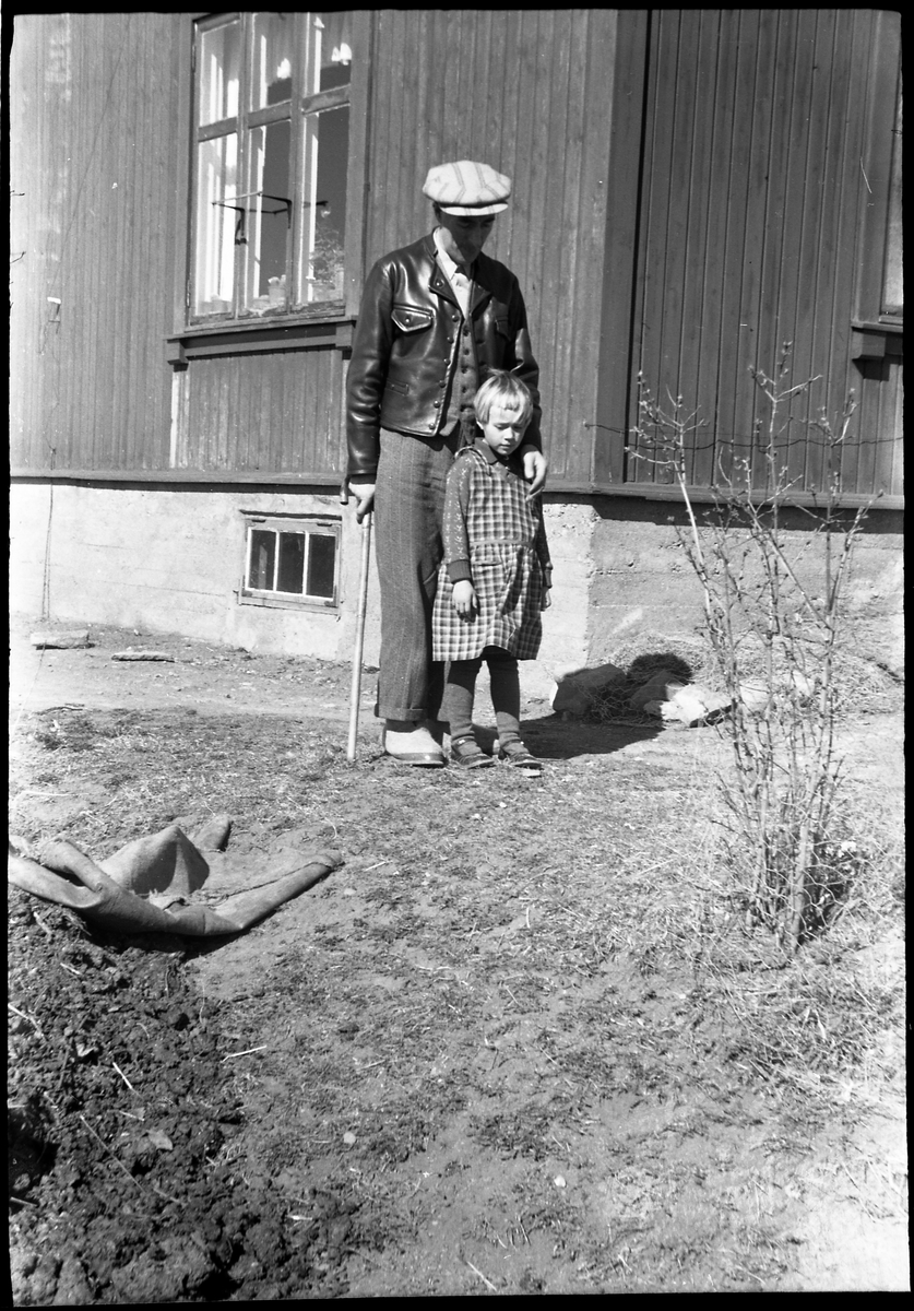 Sigurd Røisli og dattera Sigrun ved husveggen hjemme på Odberg på Kraby, Ø.Toten.