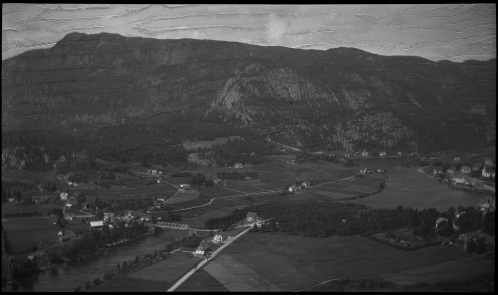 Biltur til Kvinesdal. Det er bilder tatt fra bilen fremover på veien og utover landskapet. Det er også bilder fra et tettsted ved en fjord. På bilde nr. 8 står det et hus med påskriften "HANSEN" på den andre siden av ei bru. På bilde nr. 17 sitter antageligvis Harald Bergsaker og Arne Johannessen på en stein i ei stri elv. Det er også flere bilder av en gruppe mennesker med en åpen buss. På bilde nr. 14 er L. A. B. Ådnesen til venstre.