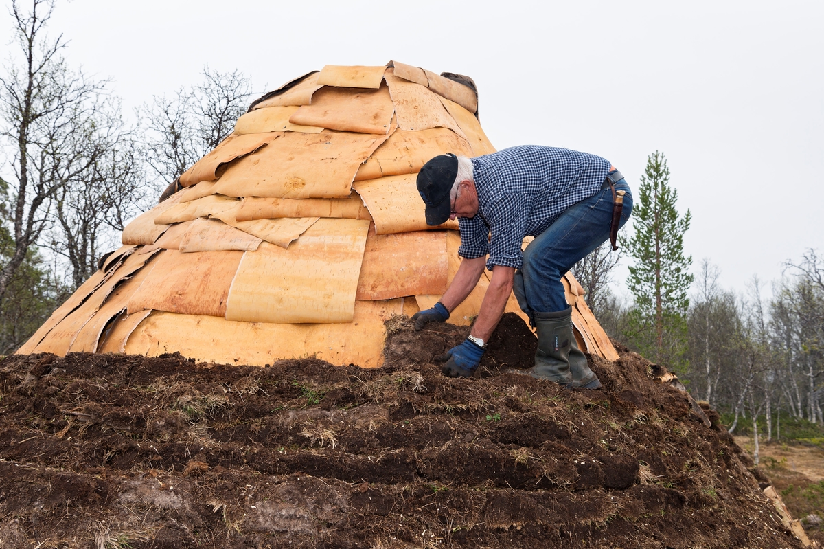 Bilde tatt i forbindelse med legging av torv på gamme. Fra gjenreisingen av Daniel Mortenssons vinterboplass ved Kjerran, Valdalsfjellet, Engerdal. Knut Arvid Hagen. Rekonstuksjon av Daniel Mortensons vinterboplass. Rekonstruksjon av samisk boplass. I følge Jonas Danielsen ble Daniel Mortensons vintergammen oppført i løpet av perioden 1900— 1902. Svahken Sijte hadde et ønske om å gjenreise en vintergamme, daelvie-gáetie, i nærheten av gammetuften, og stedet som ble valgt til formålet ligger ca. 50 meter nord for den gamme tufta. Gamma sto ferdig i begynnelsen av juni 2017, og åpningen inngikk i jubileumsmarkeringen for samenes første landsmøte i 1917, Tråante 2017. Samisk vinterboplass. Samisk kultur og historie. Daniel Mortenson. Daniel Mortensson.