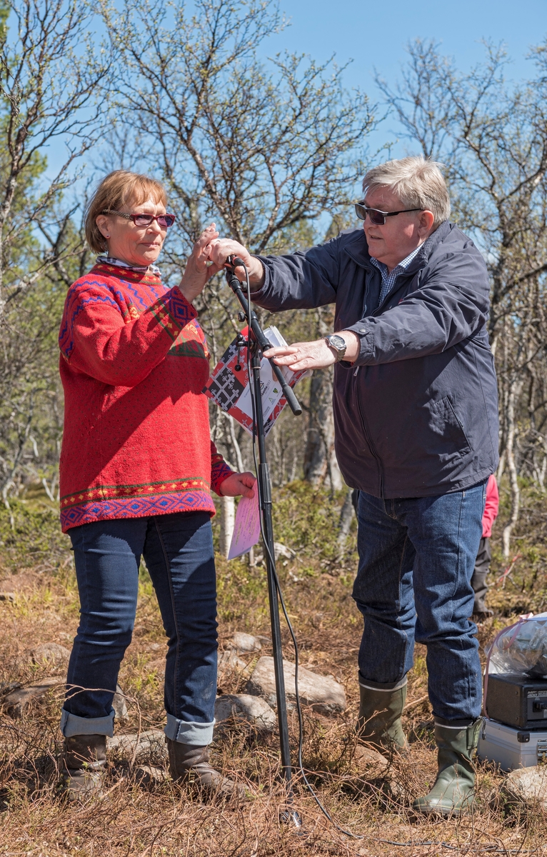 Åpning av Daniel Mortensons vinterboplass ved Kjerran på Valdalsfjellet i Engerdal, Hedmark 2/6 2017. Avdelingsdirektør ved Glomdalsmuseet Jan Hoff Jørgensen hjelper Marie Kristine Lorentzen (født Mortensson fra Svahken Sijte) med mikrofonen før hun skal holde tale.  Gamme reist i forbindelse med markeringen av 100-års jubileet for samenes første landsmøte, og åpningen inngikk i jubileumsfeiringen på Elgå 2.-4. juni 2017. Daniel Mortenson (1860-1924). Tråante 2017. Til åpningen kom over 200 personer. Boplassen består av en vintergamme med kåva og et bur i tømmer. Samisk kultur og historie.