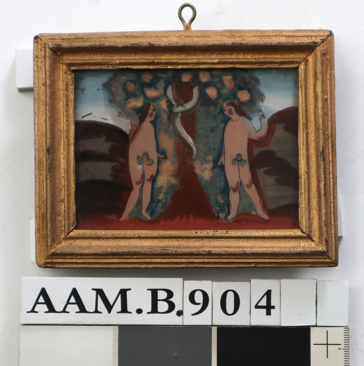 Adam og Eva under kunnskapens tre. To figurer med tynn brun konturstrek, brunt hår og fikenblad. Rødbrun stamme og  mark omkring. Blågrønt tre med store epler, hvor fargen nesten er borte. Lysblå himmel.