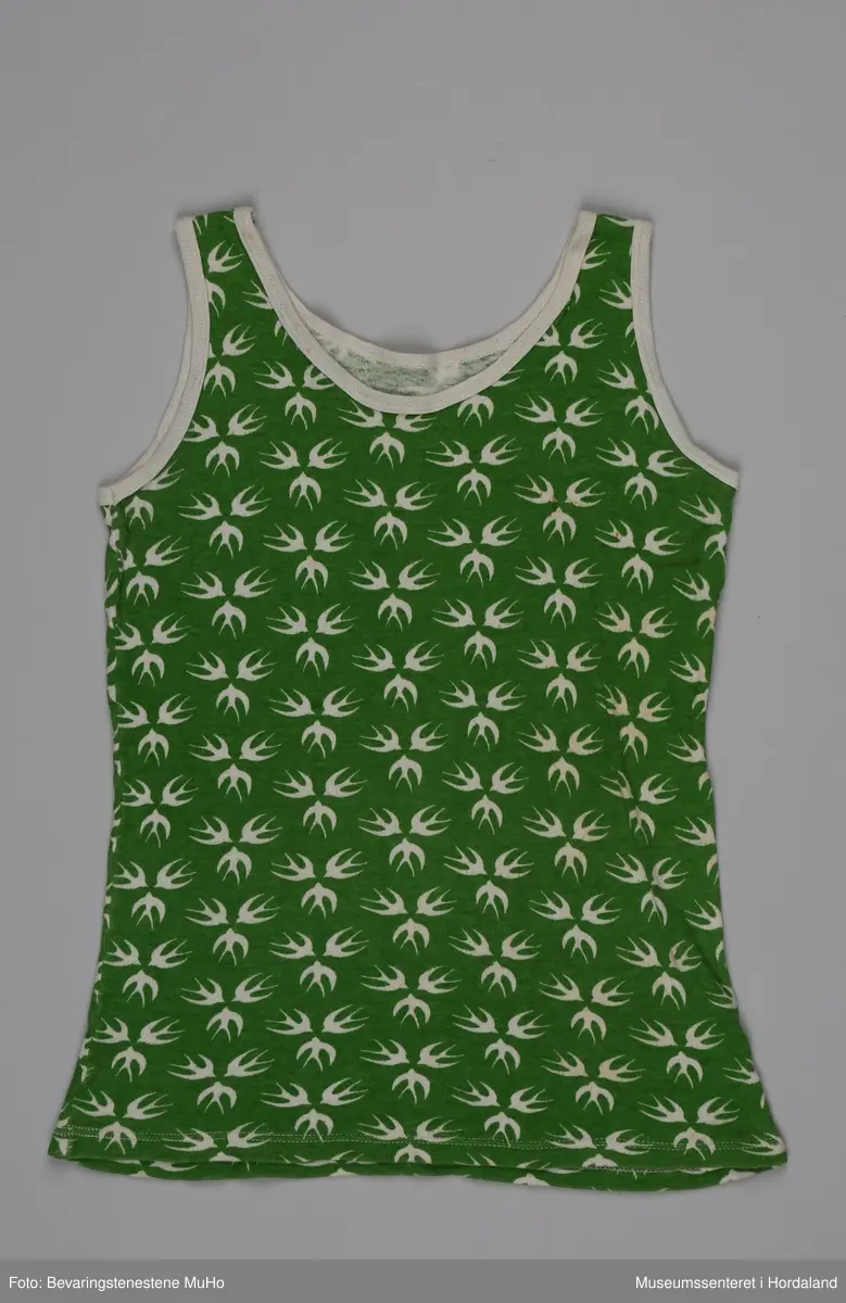 Grøn singlet med kvite svaler i merket Svale.