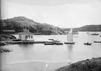 Utsikt över fjorden med båtar och bygnader vid stranden