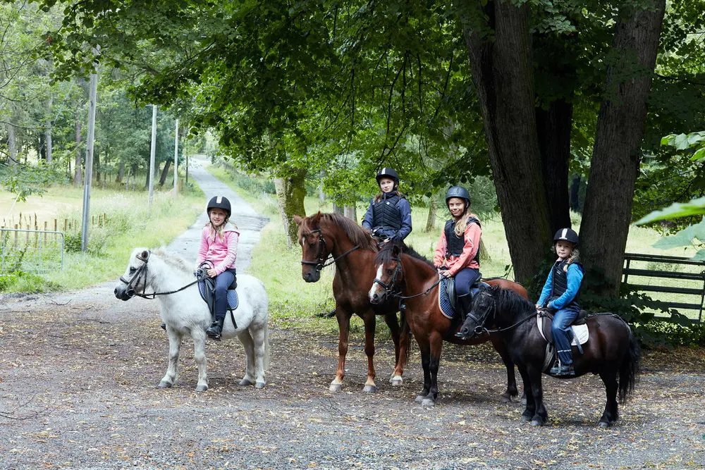 Fire barn sitter på hver sin hest. 