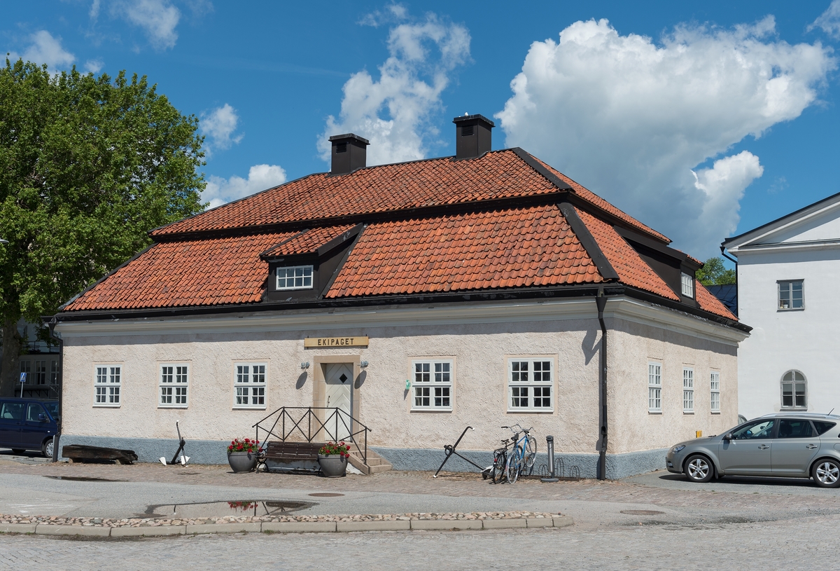 Byggnad i en våning med inredd vind. Putsad fasad i svagt rosa och säteritak med takkupor i alla väderstreck.