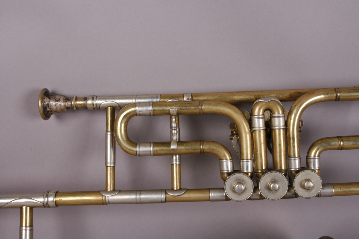Ventilbasun, eller trombone, i messing, med dreieventiler. Tilhørende munnstykke.