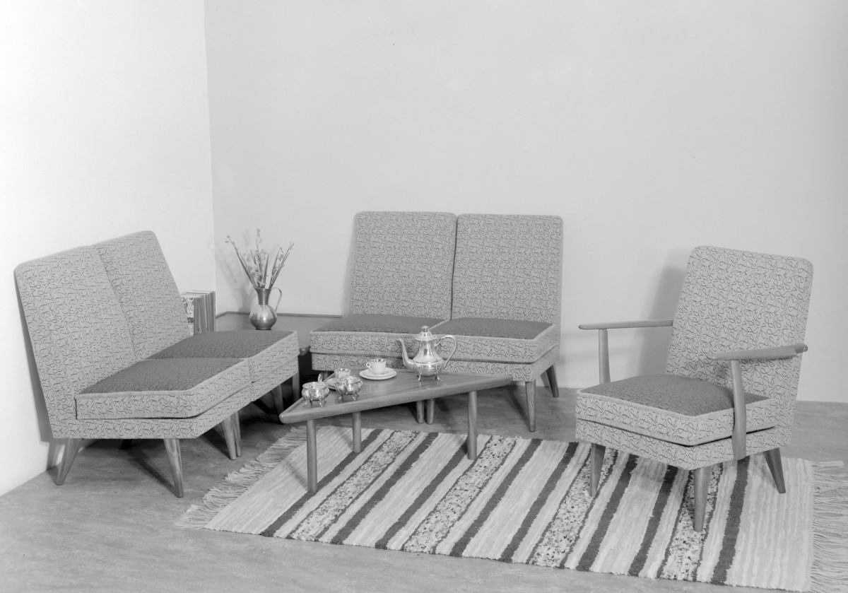 Hjørnesofa, lenestol, hjørnebord og lite salongbord.