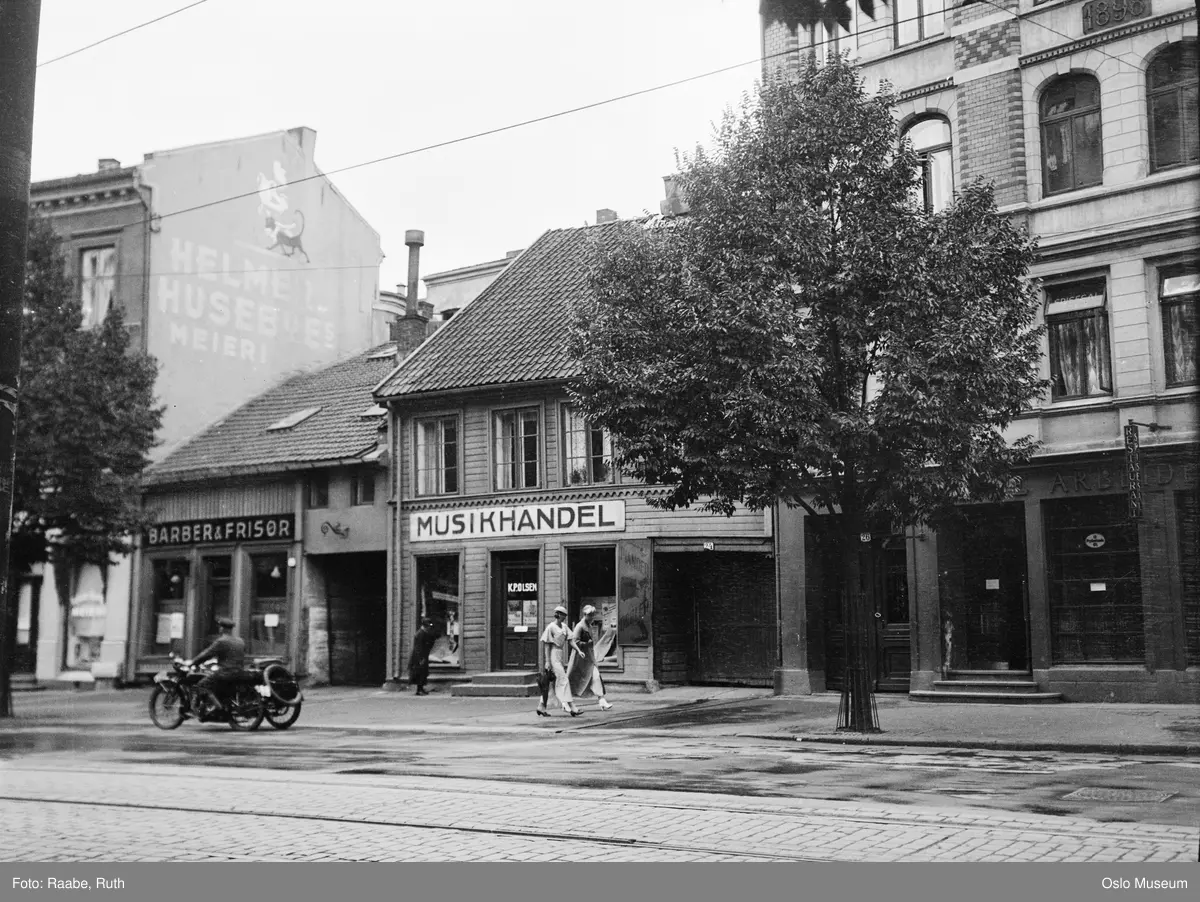 forretningsgårder, K.P. Olsen musikkhandel, barber og frisør Haakon M. Fredriksen, Østre Arbeidersamfund, resturant, mennesker, motorsykkel, trær