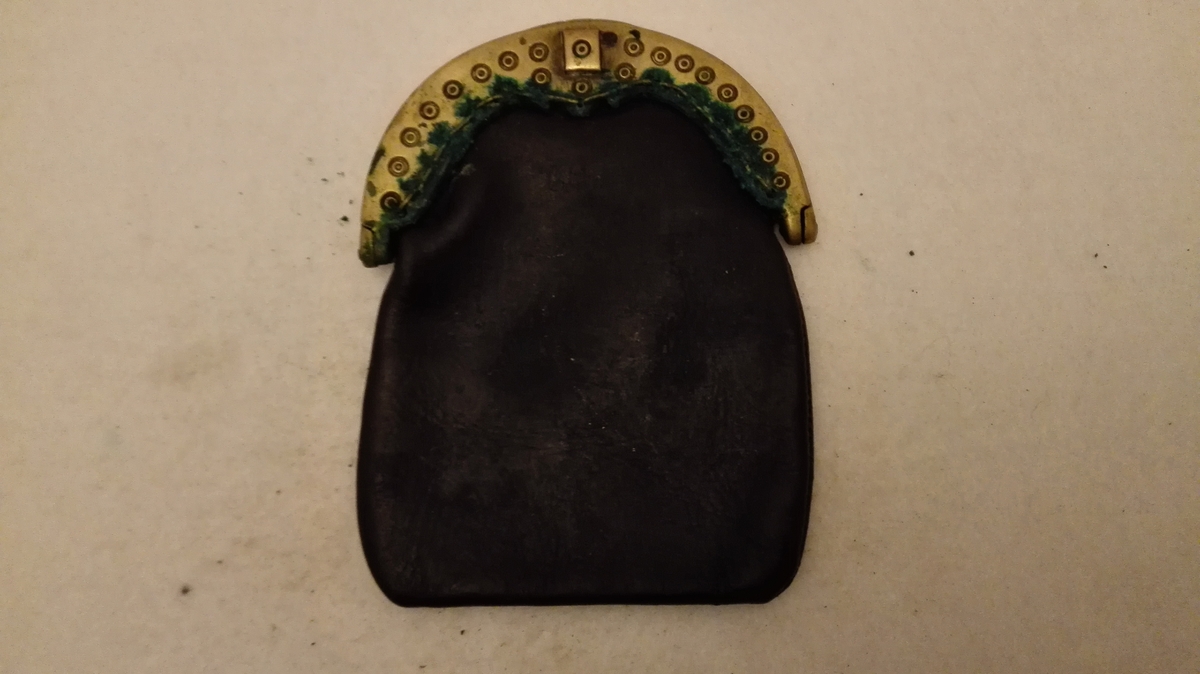 1 pung med messing laas.

Messingpungelaas med skindpung, nylig paasat. Et rum. Fjær med skyvelem. Forsirt med paastemplete ringer. Bredde 8,9 cm. 

Samtlige disse 31 no er opkjöpt paa Vikören og omliggende gaarde og av mig kjöpt av antikvitetsopkjöper Salamon Itzkowsky, Trondheim.