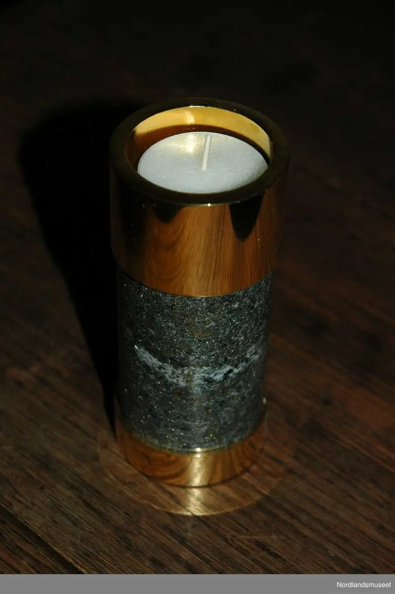 3 lysestaker med en brikke.
a: Lite lys som er laget av slipet malm og messing.
b: Mellomstort lys som er laget av slipet malm og messing.
c: Stort lys som er laget av slipet malm og messing.
d: Brikke som lysestakene står på.