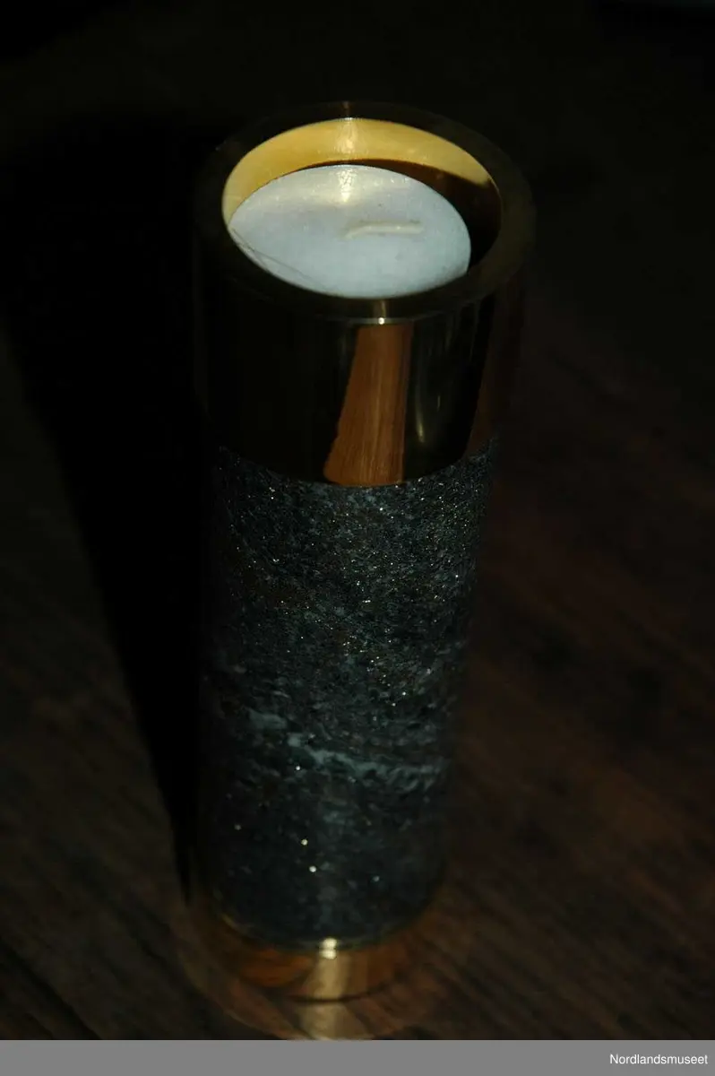 3 lysestaker med en brikke.
a: Lite lys som er laget av slipet malm og messing.
b: Mellomstort lys som er laget av slipet malm og messing.
c: Stort lys som er laget av slipet malm og messing.
d: Brikke som lysestakene står på.