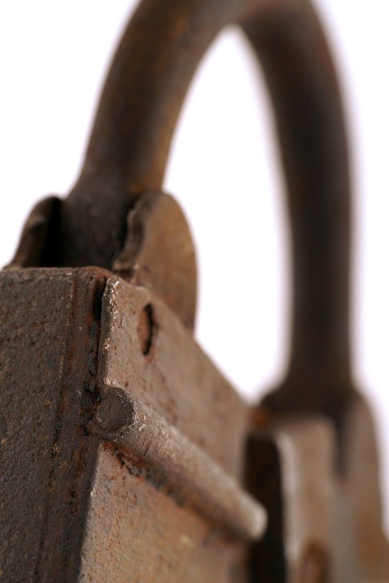 Hengelås av jern. Firkantet med svingbart lokk over nøkkelhull. I tillegg er det et ekstra lokk over låsbøylens ende.
Enden av låsbøylen hadde et hull, som gjorde at låsen kunne forsegles, ved at det ble trukket en forseglingstråd
gjennom låsbøylens ende og deretter plombert med en bly - eller lakk-plombe. Lokket beskyttet så forseglingen.