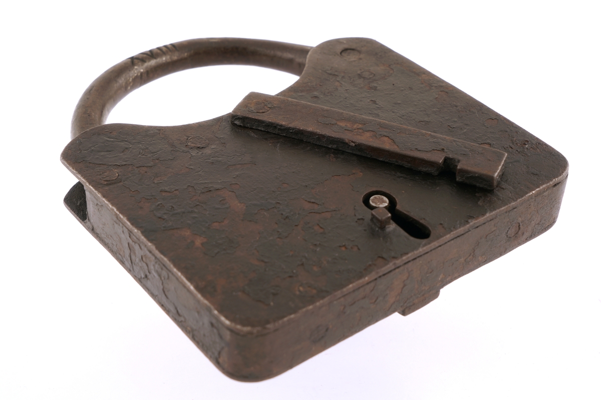 Hengelås av jern med nøkkel. Firkantet med svingbart, rektangulært lokk over nøkkelhullet.