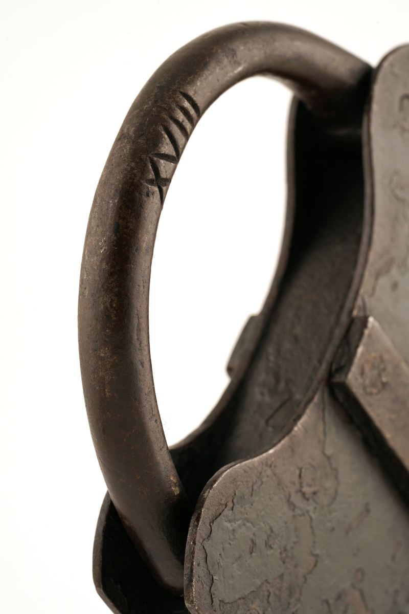 Hengelås av jern med nøkkel. Firkantet med svingbart, rektangulært lokk over nøkkelhullet.