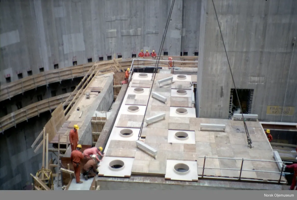 Draugen er under bygging i Jåttåvågen ved Stavanger.
Mye forskjellig utstyr og dekk skal monteres under byggeprosessen.
Dekk heises på plass i betongskaftet.