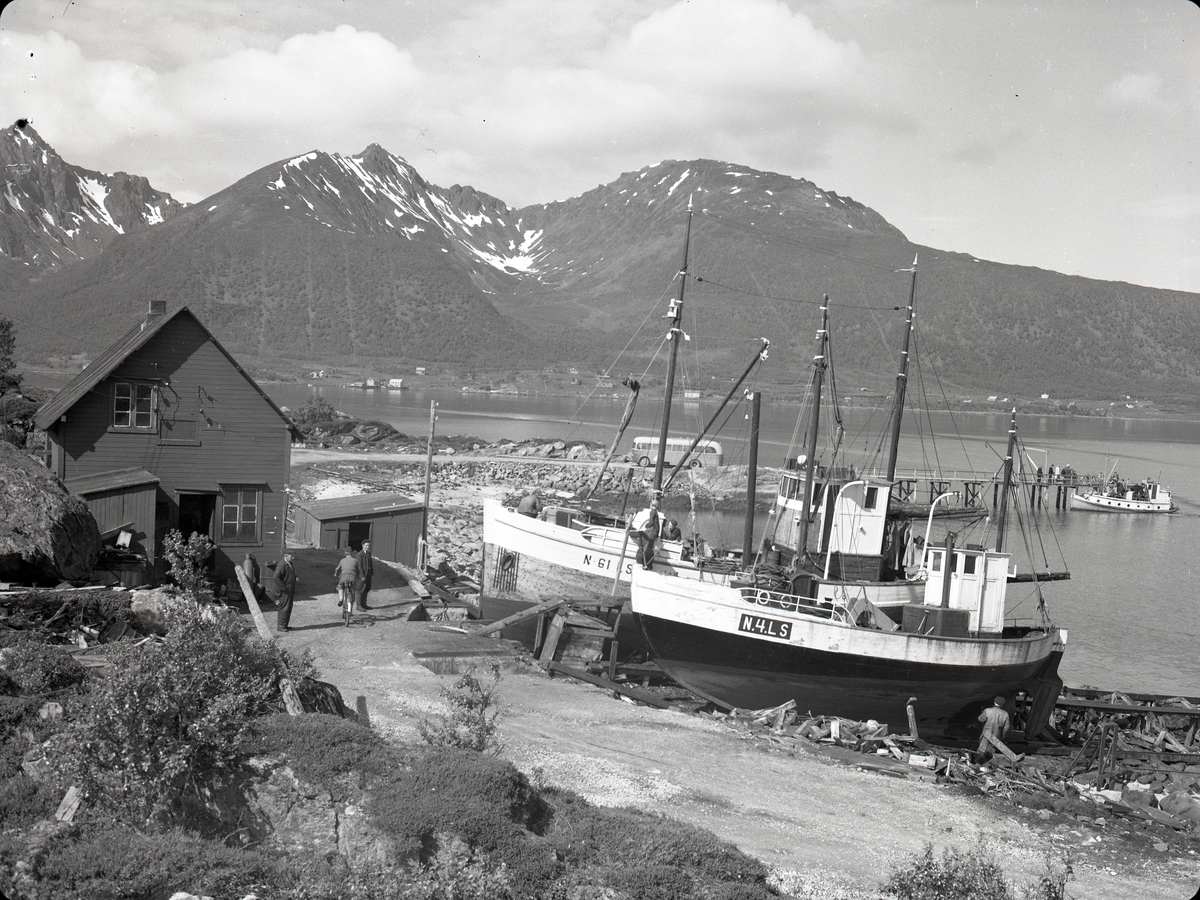 Slippen og kaia på Holm ca. 1952. Holm lå på denne tida i Langenes kommune, men ble senere overført til Sortland. Ifølge Merkeregisteret for 1952 er båtene N-4-LS MS Arnold og N-61-LS MK Solbris. Bussen fra Sortland korresponderte med rutebåten over Lifjorden til Toftenes.

Opplysning fra seer: Bildet kan være tatt av Ivar Toften.