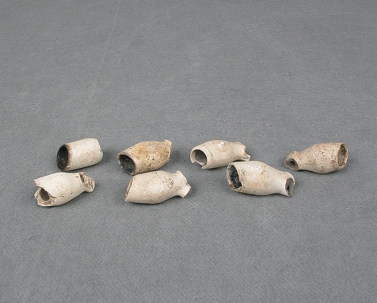 Arkeologiskt föremål. Del av en kritpipa, piphuvud av vit-bränd piplera. Vitt.