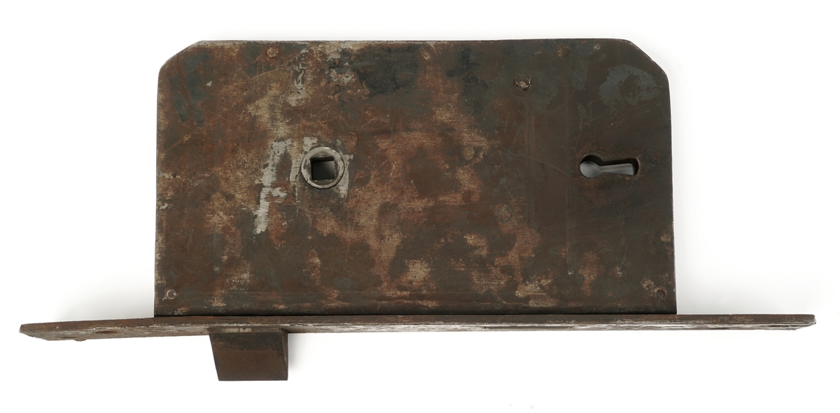 Dørlås for innmontering i dør av jern. Det medfølger tre monteringsbraketter, som selve låsen har vært montert på. Låskassen er rektangulær, med avrundede hjørner på den ene siden, og et større, flatt jern på den motsatte siden.Nøkkel følger med