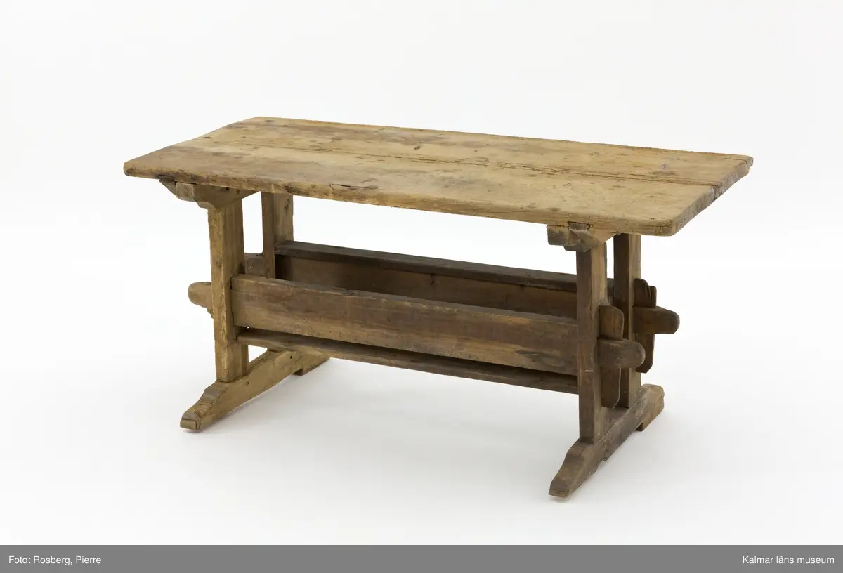 KLM 11169. Bord, långbord. Av furu. Avlångt bord med två ben på vardera kortsida samt lös bordsskiva med rektangulär form. Undertill en avlång låda som håller samman benen. Omålat. Väl använt.