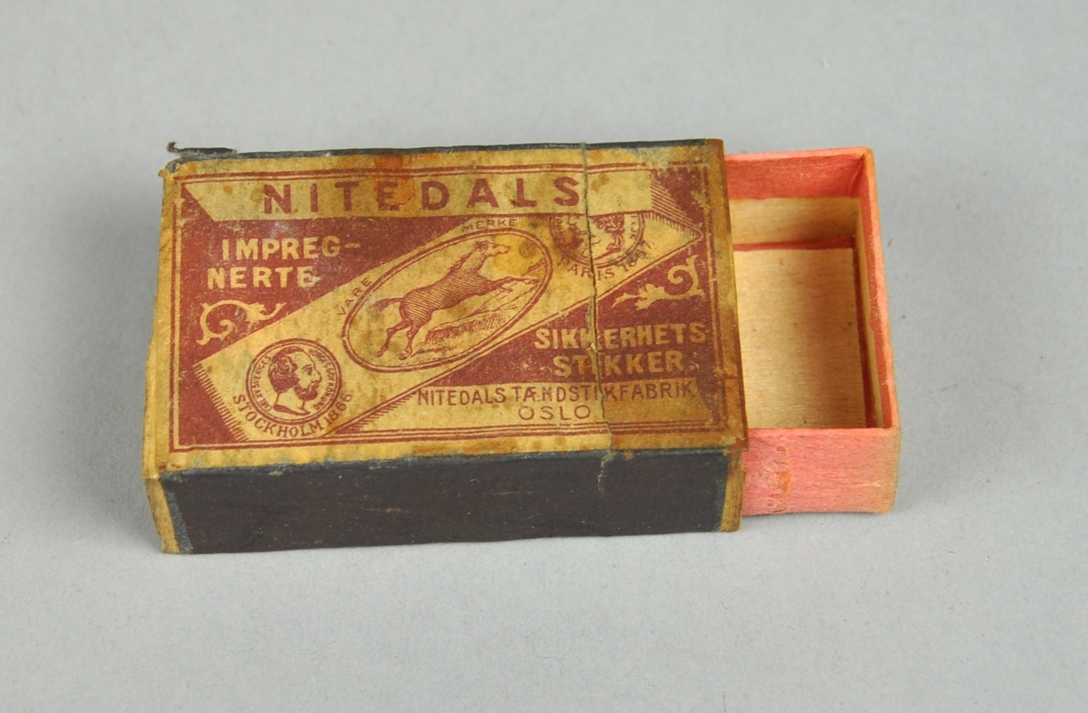 Fyrstikkeske bestående av to deler, en eske som er trukket med rosa papir og kan skyves inn i en annen. På oversiden vises produsentnavnet på et diagonalt bånd med en hest og to mannshoder. På begge sider er det ripeflater. Reklame på baksiden.