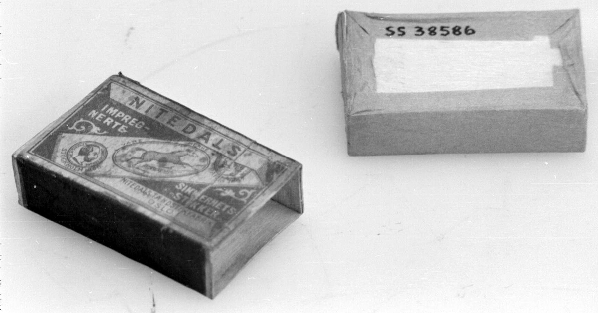 Fyrstikkeske bestående av to deler, en eske som er trukket med rosa papir og kan skyves inn i en annen. På oversiden vises produsentnavnet på et diagonalt bånd med en hest og to mannshoder. På begge sider er det ripeflater. Reklame på baksiden.