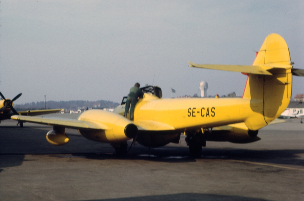 Gulmålat målbogserflygplan av typ Gloster Meteor T.7 med civilt registreringsnummer SE-CAS på Bromma flygplats, i början av 1970-talet. Flygförare och flygtekniker i arbete. Serie om 7 bilder.