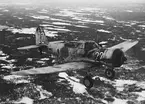 F6 Karlsborg 1943. Vintercamoflerad B5:a ur 2. divisionen på väg mot vinterövningen i Norrland. Flygförare Engvall och flygsignalist Boman. Albumet är en del av en donation från Karl-Axel Hansson, Karlsborg. Förteckning över hela donationen finns i albumet samt som Word-dokument.