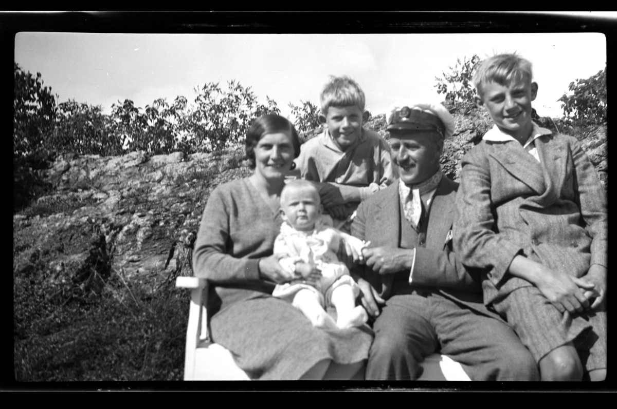 Hilda og Rolf Sundt sr. sitter med sine tre sønner Lars Peter, Rolf jr. og Julius på en benk, Konglungen. Fotografert 1930.