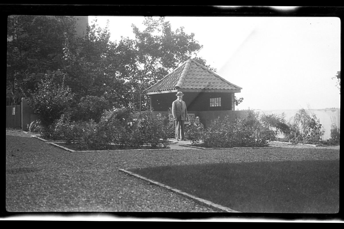 Rolf Sundt sr. står foran et lysthus, Thomas Heftyes gate 42, Oslo. Fotografert 1926.