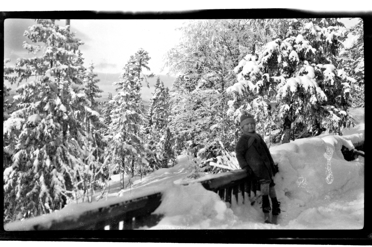 Julius Sundt står ved gjerde med masse snø rundt, Villa Knyggen. Fotografert 1921.