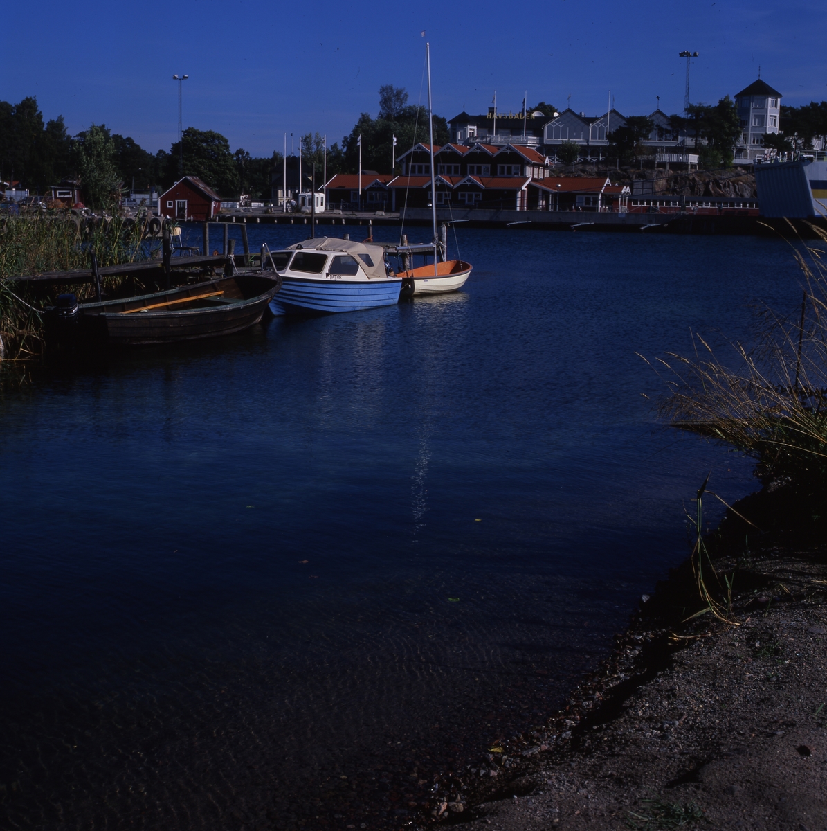 Fogdö, en ö i norra Roslagen, 2-3 september 1999.  Här ser vi Hotell Havsbaden, några båtar vid en brygga och flera byggnader vid vattnet.