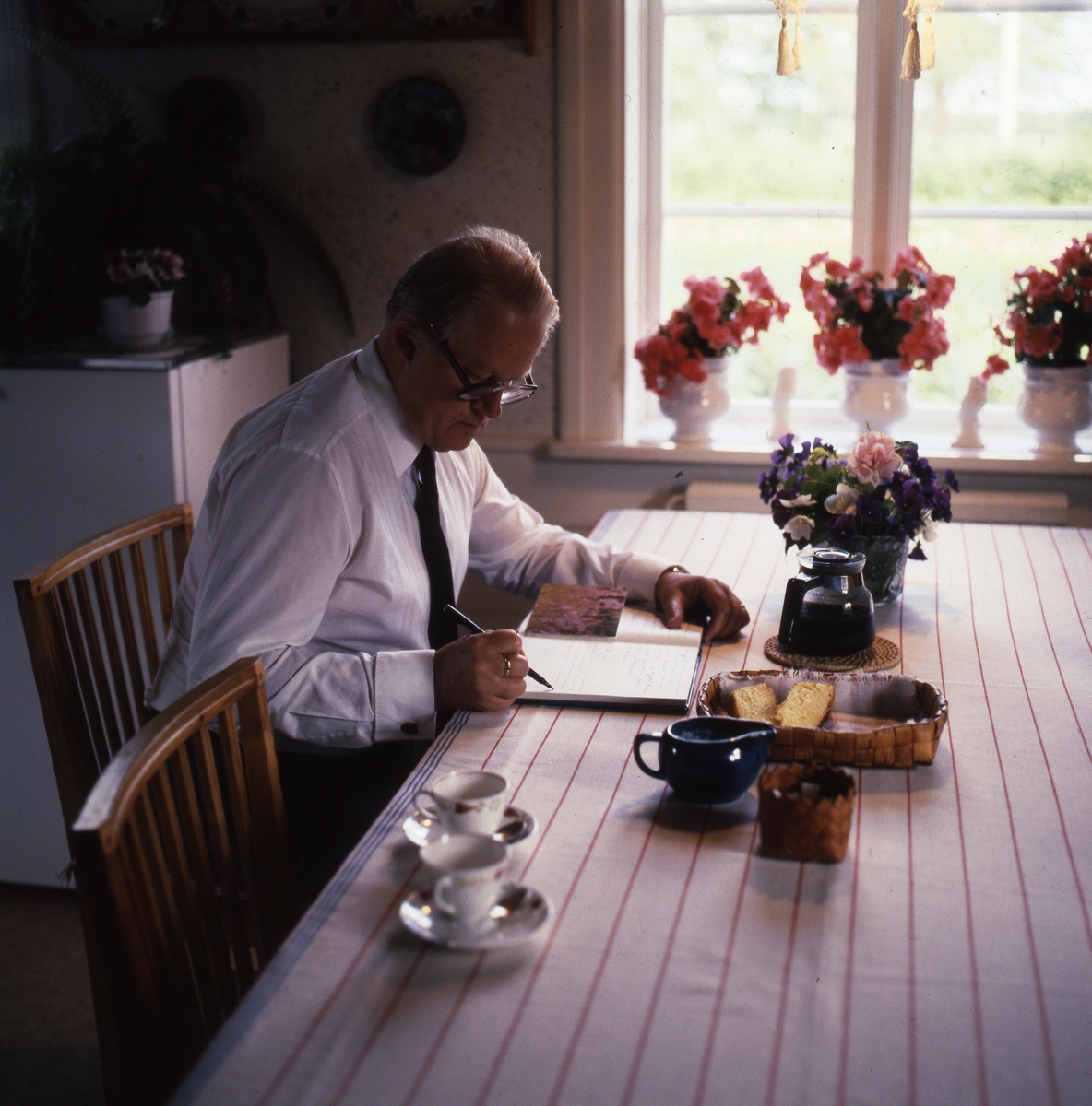 Bo Setterlind skriver i gästboken i köket 22 juli 1984.