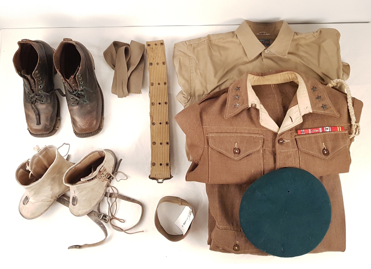 Uniformen består av jakke, bukse, beret, skjorte, slips, armbind, belte, gamasjer og støvler.