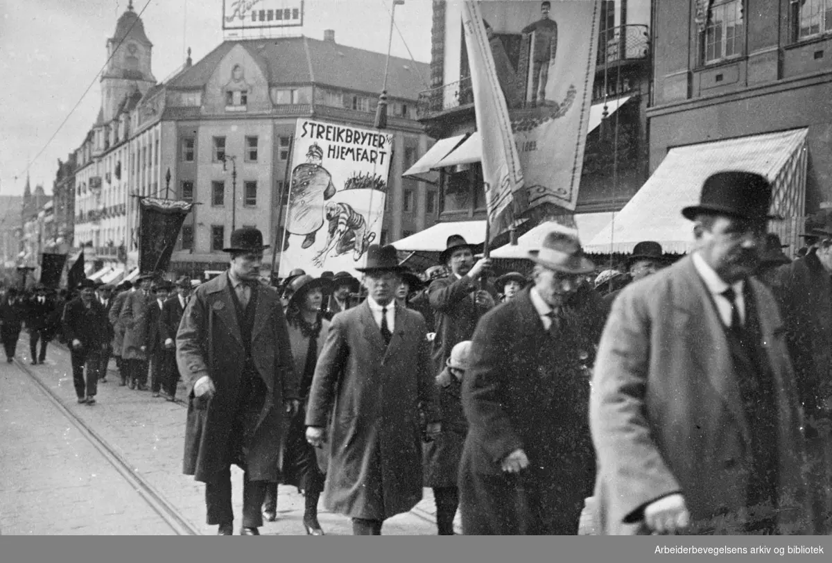 1. mai 1924. Demonstrasjonstoget er på vei nedover Karl Johans gate. Parole: Streikbryter'ns hjemfart. Fanen tilhører Grønvold Fyrstikarbeideres fællesforening.